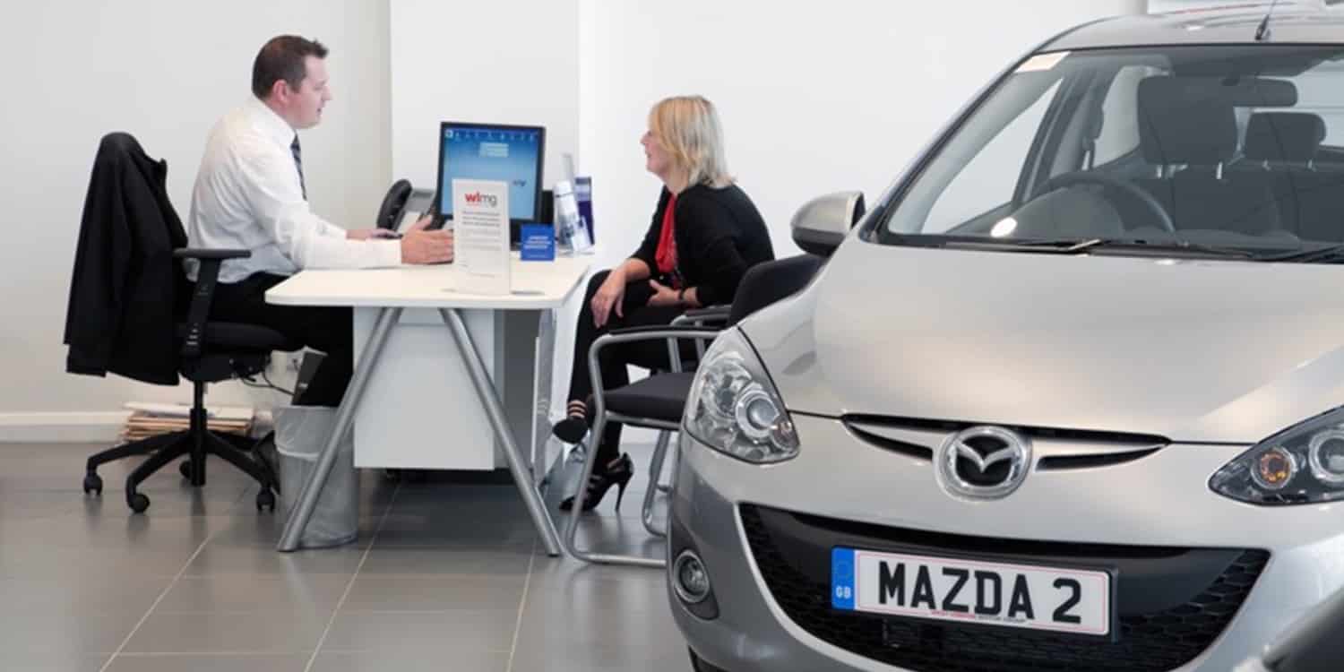 Discussing car finance, like a hire purchase or PCP, in a car showroom
